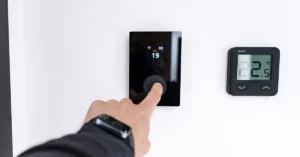 Smart thermostat displaying 78 degrees and energy savings data in modern Utah living room
